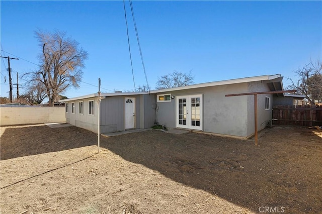 back of property with french doors and a wall mounted AC