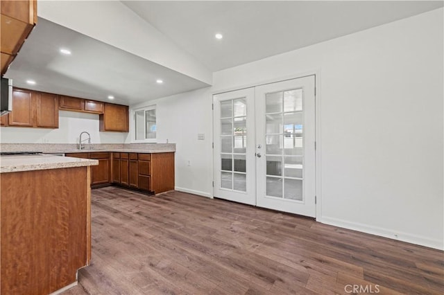 kitchen featuring sink, french doors, vaulted ceiling, and hardwood / wood-style flooring