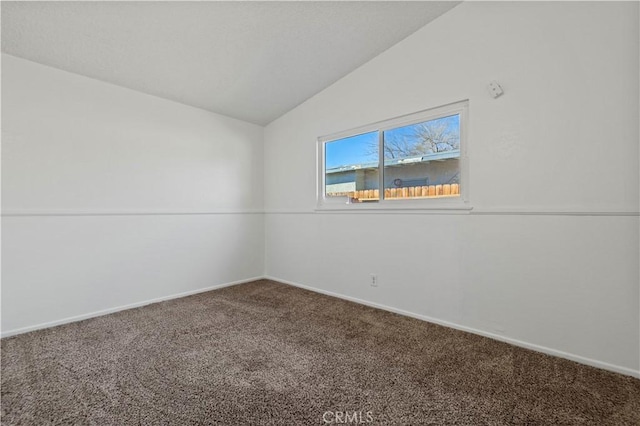 carpeted empty room featuring lofted ceiling