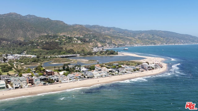 aerial view with a water and mountain view and a view of the beach