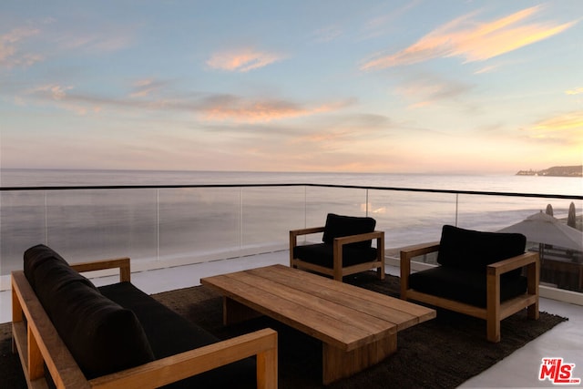 patio terrace at dusk featuring a water view