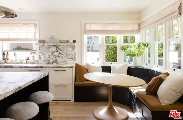 dining area with sink, breakfast area, and light hardwood / wood-style flooring