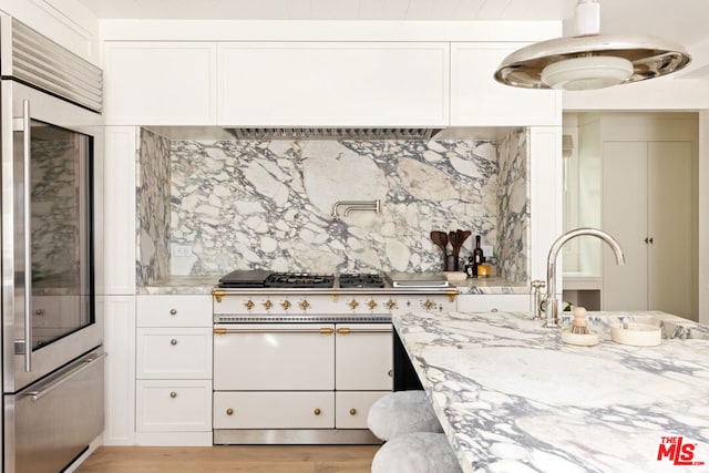 kitchen with white cabinets, backsplash, and sink