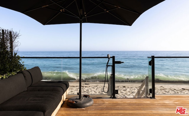 balcony featuring a beach view and a water view