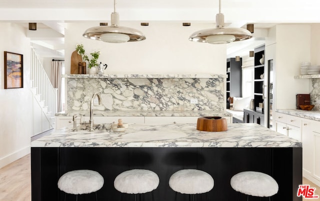 kitchen with decorative light fixtures, a breakfast bar, and tasteful backsplash