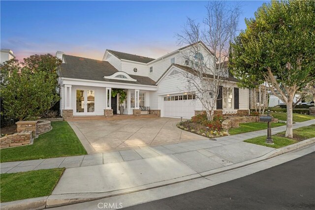 view of front of home with french doors, a yard, and a garage