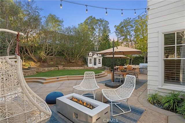 view of patio featuring a fire pit, grilling area, area for grilling, and a storage unit