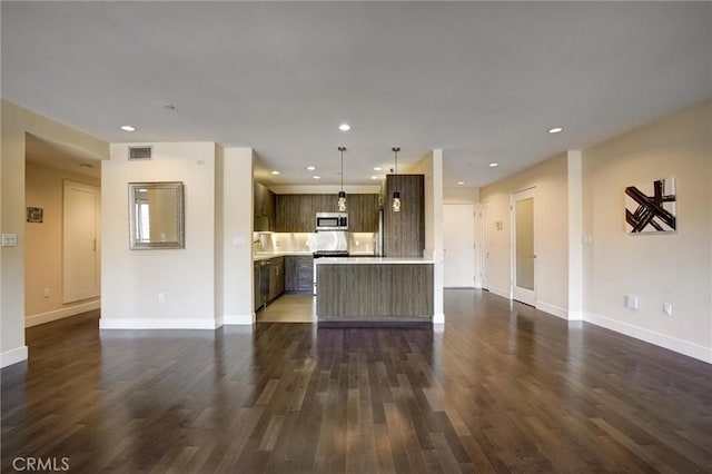 kitchen featuring hanging light fixtures, dark brown cabinetry, dark hardwood / wood-style flooring, and a kitchen island