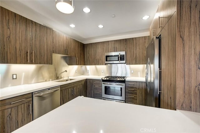 kitchen featuring stainless steel appliances, tasteful backsplash, and sink