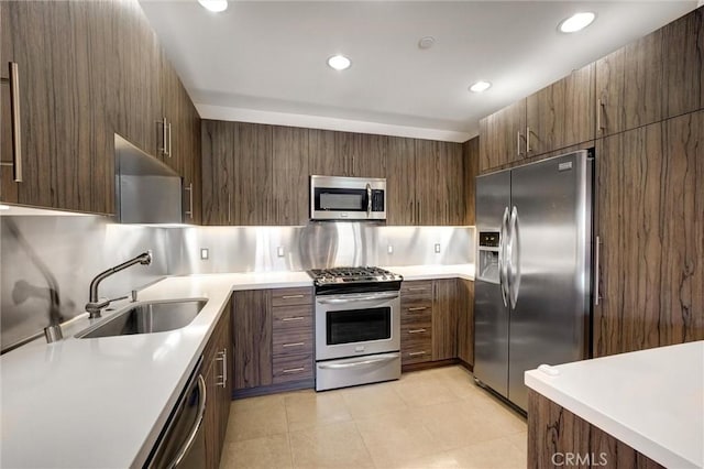 kitchen featuring tasteful backsplash, sink, stainless steel appliances, light tile patterned floors, and dark brown cabinets