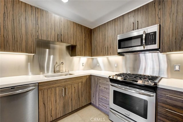 kitchen with sink, light tile patterned floors, stainless steel appliances, and tasteful backsplash