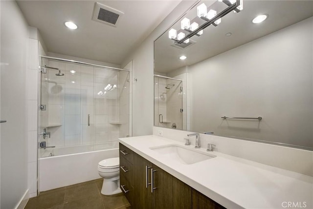 full bathroom with toilet, vanity, tile patterned flooring, and bath / shower combo with glass door