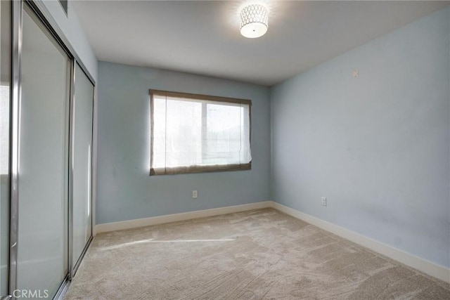 unfurnished bedroom featuring a closet and light carpet