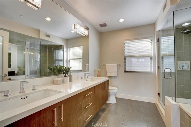 bathroom featuring a stall shower, visible vents, toilet, and a sink