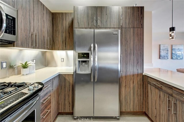 kitchen with light countertops, decorative light fixtures, and appliances with stainless steel finishes
