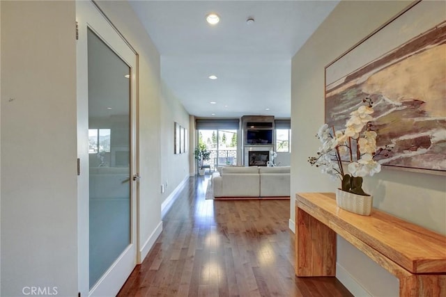 hallway with baseboards, recessed lighting, and dark wood-type flooring