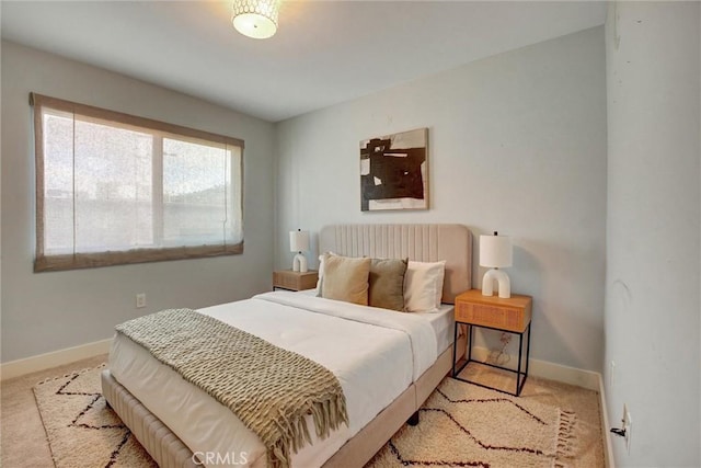 bedroom featuring light colored carpet and baseboards