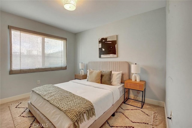 bedroom with light colored carpet and baseboards