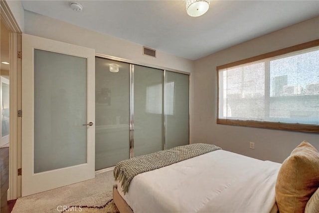 bedroom with carpet flooring, a closet, and visible vents