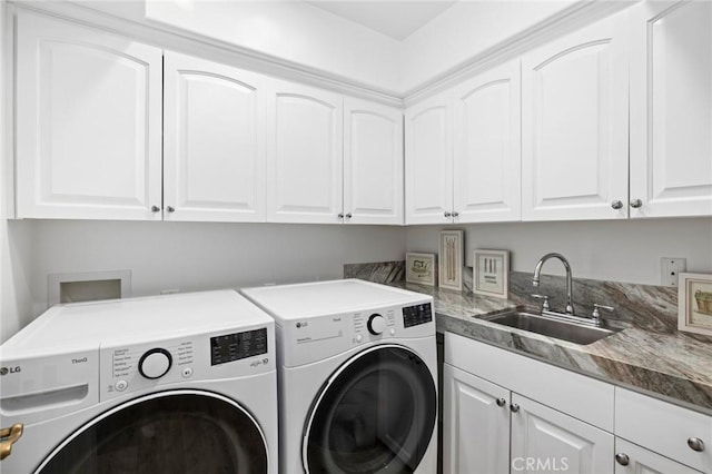 laundry room featuring cabinets, washing machine and clothes dryer, and sink