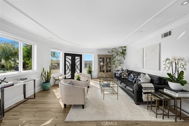 living room featuring light wood-type flooring, french doors, and ornamental molding