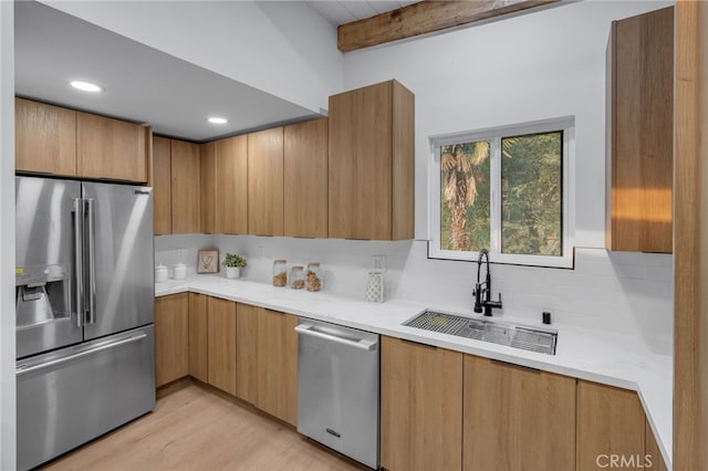 kitchen featuring light hardwood / wood-style floors, stainless steel appliances, beam ceiling, sink, and backsplash