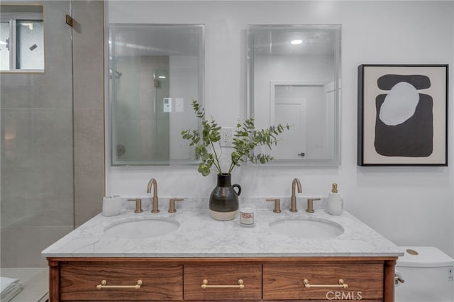 bathroom with toilet, a tile shower, and vanity