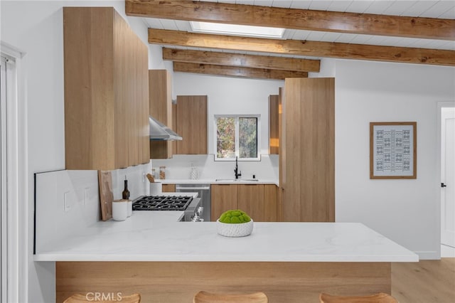 kitchen with range, beam ceiling, dishwashing machine, and sink