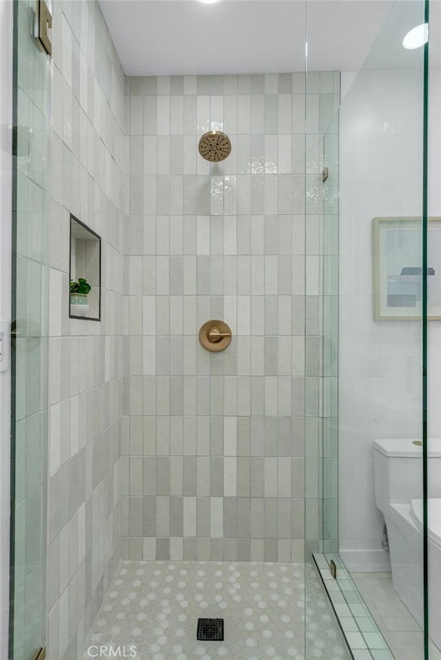 bathroom featuring toilet and a tile shower