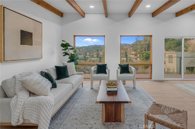 living room featuring light wood-type flooring and vaulted ceiling with beams