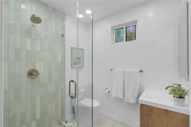 bathroom featuring toilet, a shower with door, tile patterned floors, and vanity