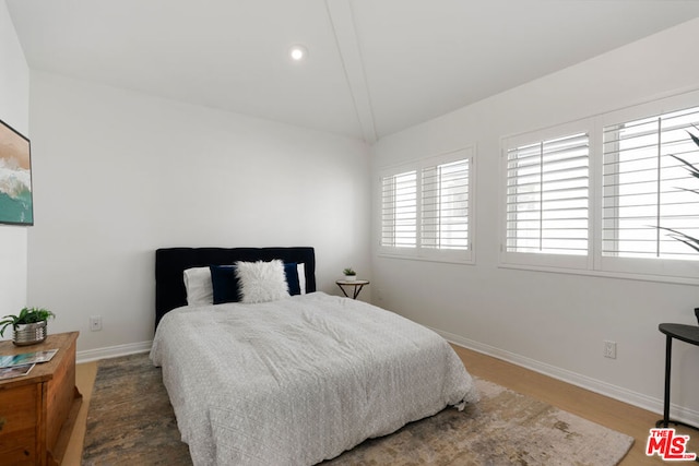 bedroom featuring hardwood / wood-style flooring and lofted ceiling