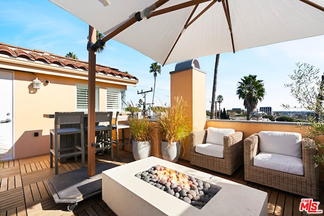 wooden terrace featuring an outdoor living space with a fire pit