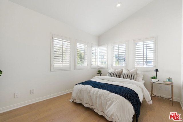 bedroom with vaulted ceiling and light hardwood / wood-style flooring