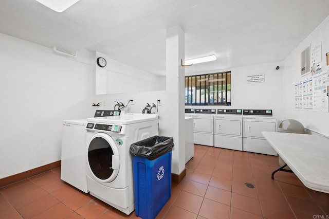 shared laundry area with washer and clothes dryer, tile patterned floors, and baseboards