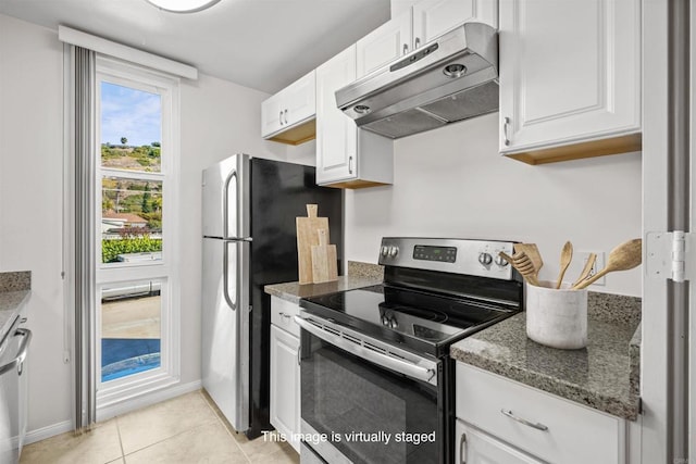 kitchen with under cabinet range hood, dark stone countertops, white cabinetry, stainless steel appliances, and light tile patterned floors