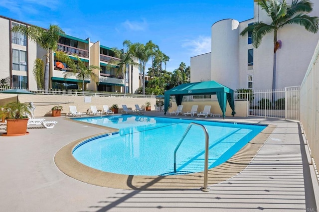 community pool featuring a patio area and fence