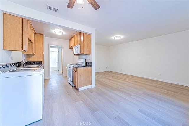 kitchen featuring sink, white appliances, ceiling fan, light wood-type flooring, and separate washer and dryer