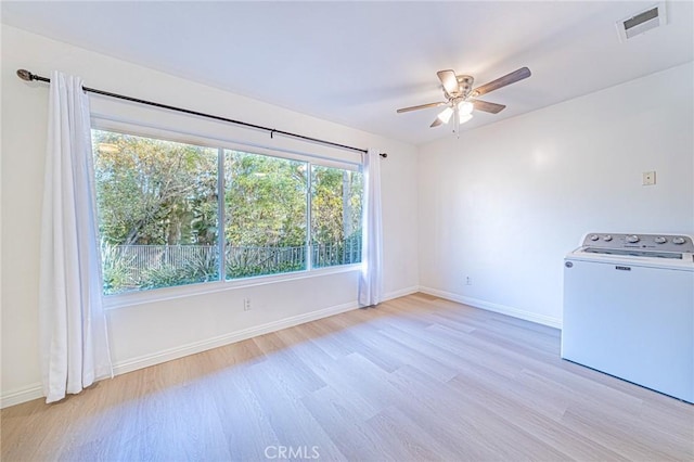 empty room featuring washer / clothes dryer, ceiling fan, and light hardwood / wood-style flooring