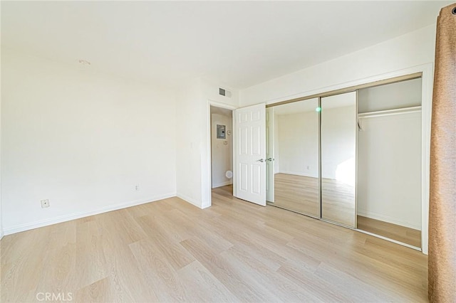 unfurnished bedroom featuring a closet and light hardwood / wood-style floors