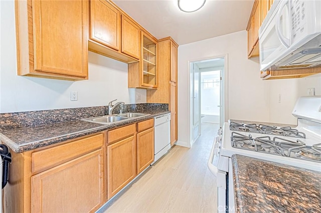 kitchen featuring sink, white appliances, dark stone countertops, and light hardwood / wood-style floors