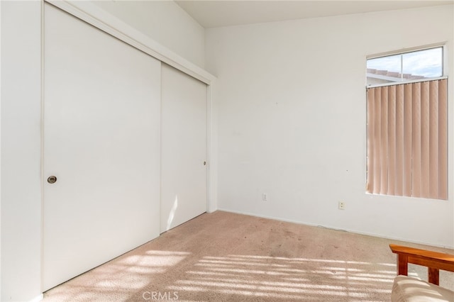 unfurnished bedroom with carpet flooring and a closet