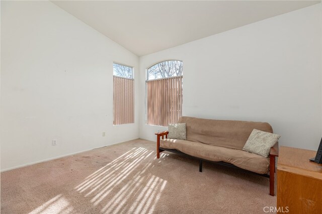 sitting room with lofted ceiling and light colored carpet