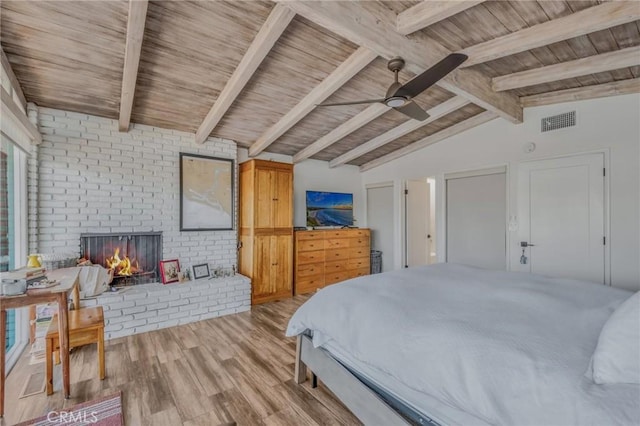 bedroom with brick wall, a fireplace, lofted ceiling with beams, wooden ceiling, and light wood-type flooring