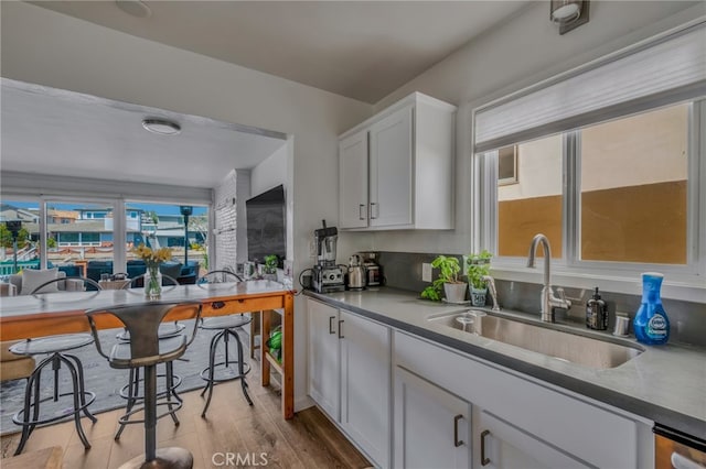 kitchen with sink, light hardwood / wood-style flooring, and white cabinets