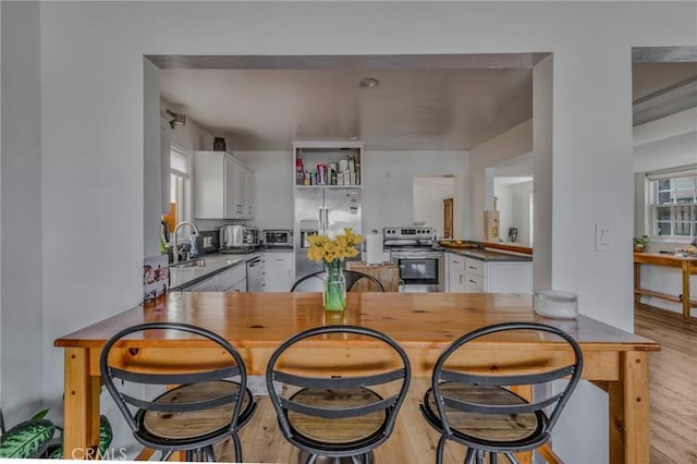 kitchen featuring white cabinets, kitchen peninsula, and appliances with stainless steel finishes