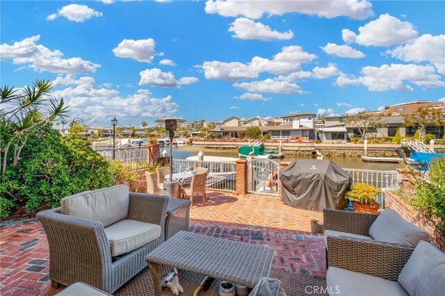 view of patio with outdoor lounge area, a grill, and a water view