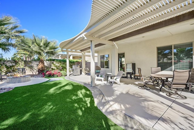 view of patio with area for grilling, a fire pit, and a pergola