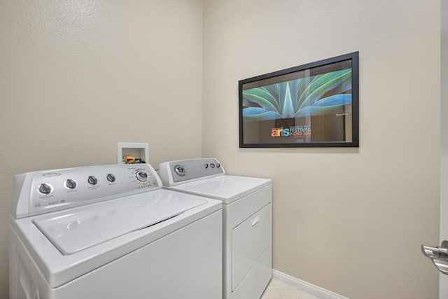 laundry room with washing machine and dryer and light tile patterned floors