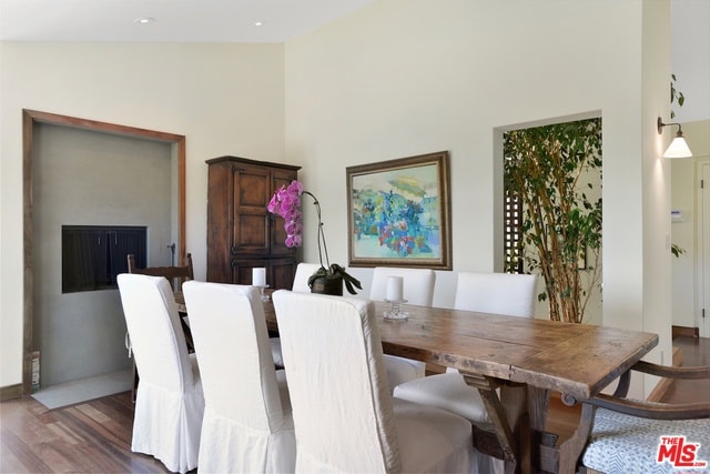 dining space featuring vaulted ceiling and dark hardwood / wood-style flooring